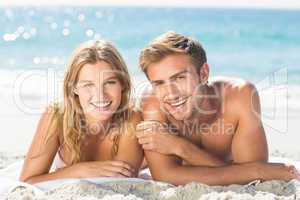 Happy couple relaxing together in the sand