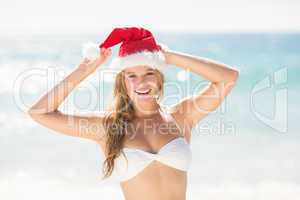 Happy pretty blonde looking at camera with santa claus hat
