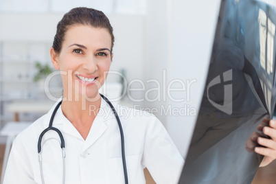 Smiling doctor looking at camera with Xray