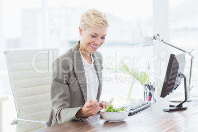 Businesswoman eating salad on her desk