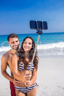 Happy couple taking a selfie at the beach