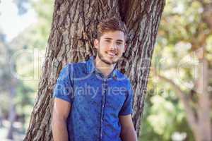 Handsome hipster smiling in the park