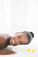 Pretty woman lying on massage table smiling at the camera