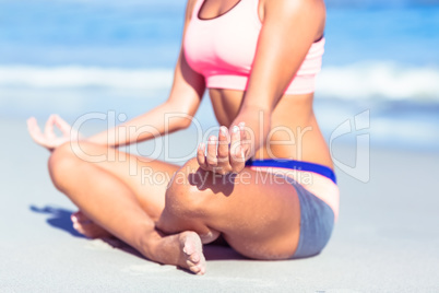 Close up view of fit woman doing yoga beside the sea