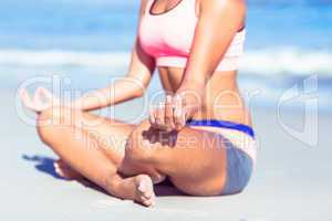 Close up view of fit woman doing yoga beside the sea