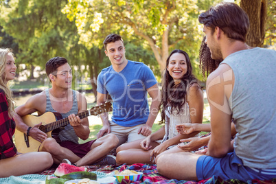 Happy friends in the park having picnic