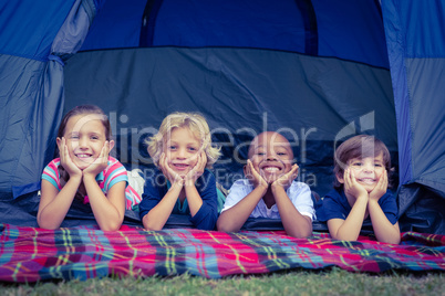 Smiling kids lying in the tent together