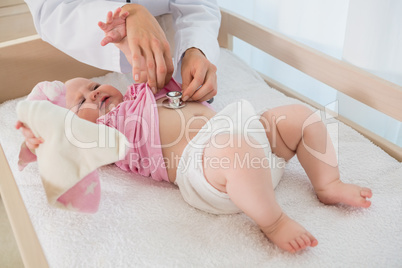 Beautiful cute baby girl with doctor with stethoscope