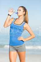 Portrait of beautiful fit woman drinking water