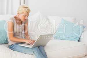 Angry blonde woman using her laptop