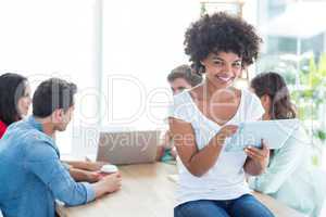 Colleagues using laptop and tablet in office