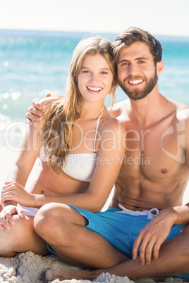 Happy couple relaxing together in the sand