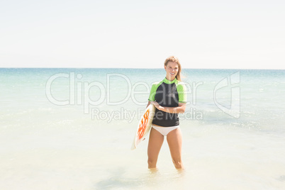 Pretty blonde woman holding surf board