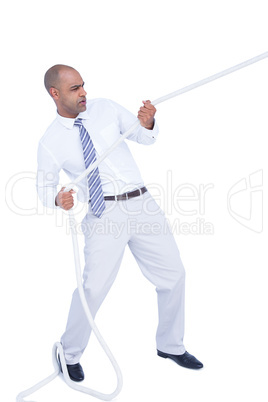 Businessman pulling a rope with effort
