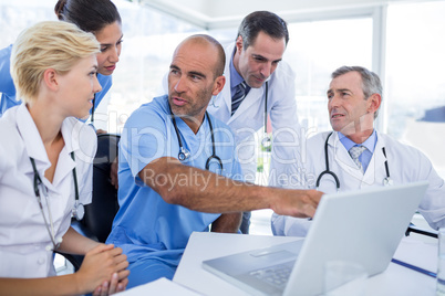 Doctor showing laptop pc to his colleagues