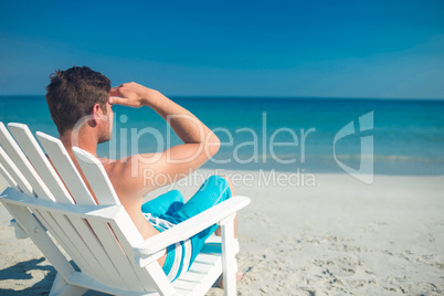 Man relaxing on deck chair at the beach