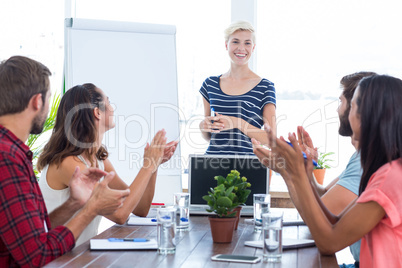 Colleagues clapping hands in a meeting
