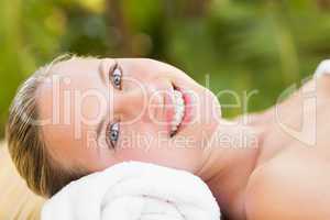 Peaceful blonde lying on towel smiling at camera