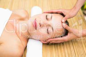 Attractive young woman receiving facial massage at spa center