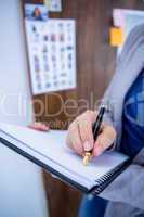 Creative businesswoman writing on notebook