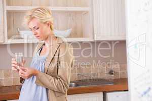 Portrait of a blonde pregnancy taking a vitamin