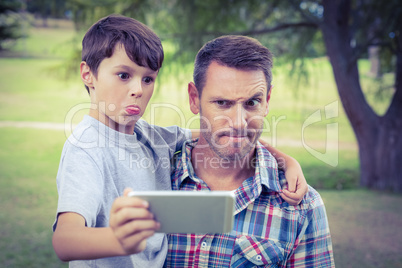 Father and son taking a selfie in the park