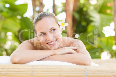 Peaceful blonde lying on towel with candle
