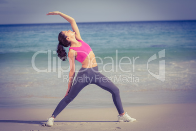 Fit woman making stretching on the beach
