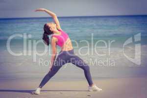 Fit woman making stretching on the beach