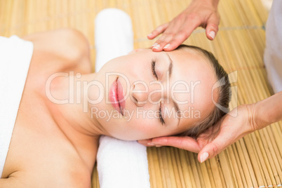 Attractive young woman receiving facial massage at spa center