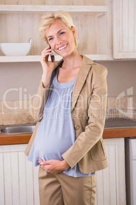 Smiling blonde pregnancy phoning