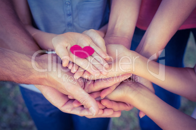 Happy family in the park holding a heart