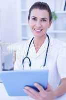 Smiling doctor using tablet computer