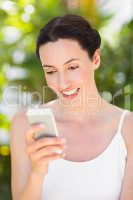 woman in white looking at her phone