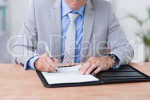 Businessman writing on a paper