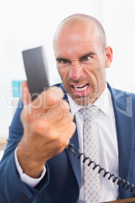Businessman yelling at his phone Businessman yelling at his phone