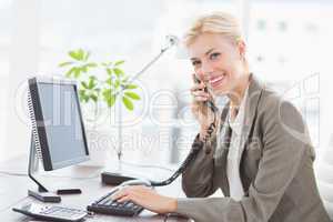 Businesswoman on the phone and using her computer