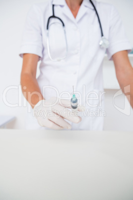 Doctor showing syringe to camera