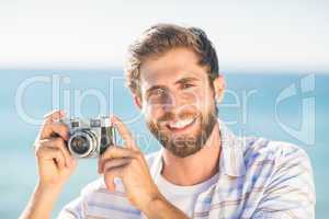 man taking a photo and looking at camera