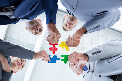 Business colleagues holding piece of puzzle