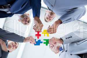 Business colleagues holding piece of puzzle