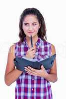 Pretty brunette thinking and holding notebook