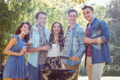 Happy friends in the park having barbecue