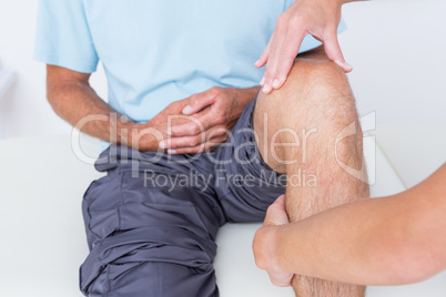 Doctor examining her patient knee