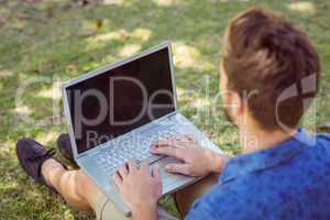 Young man using laptop in the park