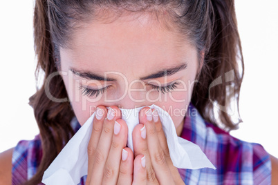 Pretty brunette woman blowing her nose