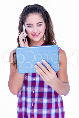 Happy pretty brunette using tablet computer and having phone cal