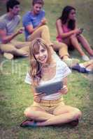 Pretty blonde using tablet in the park