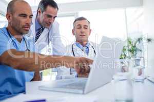 Doctor showing laptop pc to his colleagues