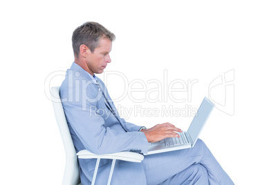 Handsome businessman sitting on a swivel chair and using his lap